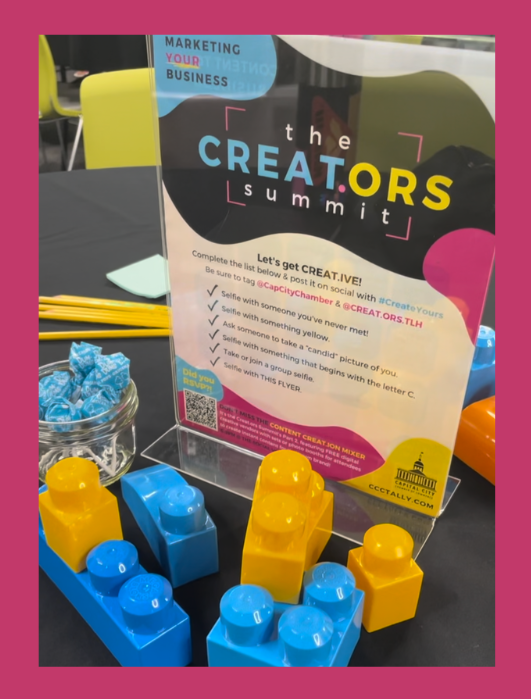 This is a photo of the table display, including building blocks, blue dum-dum lollipops, and the signage.